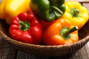 Hasır sepetteki taze dolmalık biberler masada, yakın plan.