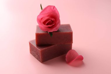 Sabun çubukları ve pembe arka planda güzel bir gül, yakın plan.