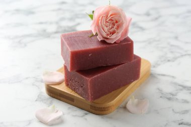 Sabun çubukları ve beyaz mermer masada güzel bir gül, yakın plan.