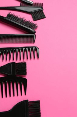 Pembe arka planda farklı kuaför aletleri, düz yatış. Metin için boşluk