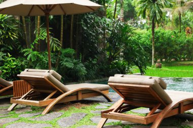 Lüks bir tatil köyünde havuz kenarında boş güneşlik.