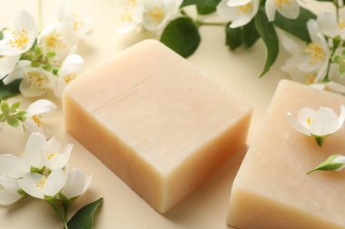 Bej arka planda sabun ve yasemin çiçekleri, yakın plan.