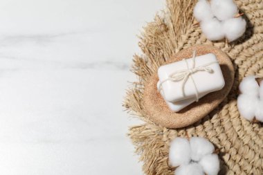 Sabun çubukları ve pamuk çiçekleri beyaz mermer masada, düz yerde. Metin için boşluk