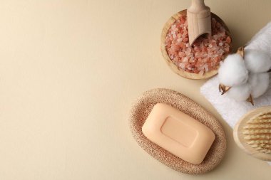 Düz kompozisyon, sabun çubuğu, deniz tuzu ve bej arka planda pamuk. Metin için boşluk