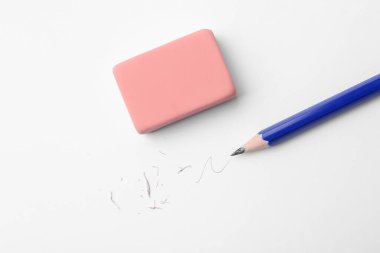 Beyaz arka planda kalem, silgi, karalama ve kırıntılar, düz uzanma