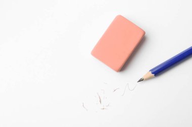 Kalem, silgi, beyaz arka planda karalama ve kırıntılar, düz yatış. Metin için boşluk