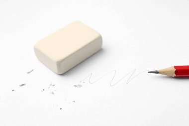 Beyaz arkaplanda kalem, silgi, karalama ve kırıntılar, yakın plan
