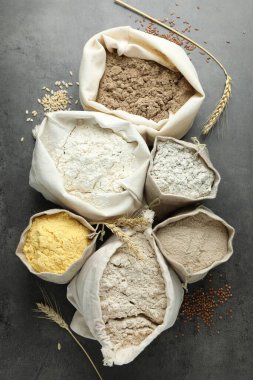 Gri masadaki poşetlerdeki farklı un türleri, düz yatıyordu.