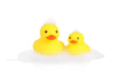 Tatlı plastik ördekler ve köpükler ayna yüzeyinde beyaz arka planda