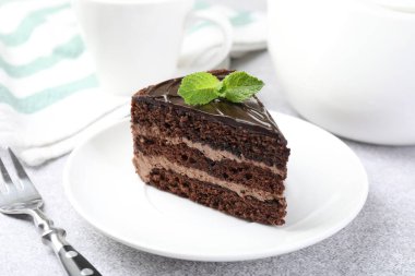 Gri masadaki çatal ve naneli çikolatalı kek, yakın plan.