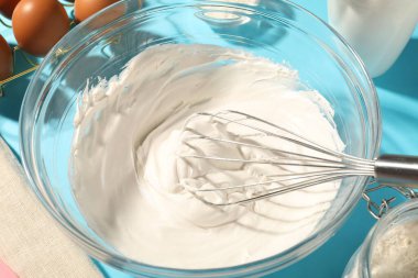 Açık mavi masada çırpılmış krema, yakın plan.