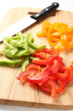 Beyaz masada taze dolmalık biber dilimleri, yakın plan.