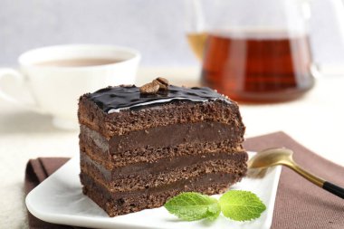 Nane, kaşık ve çayla servis edilen çikolatalı kek.