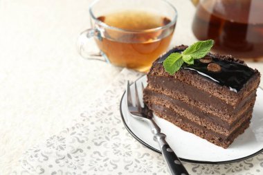Nane, çatal ve çayla servis edilen bir parça çikolatalı kek, yakın plan. Metin için boşluk