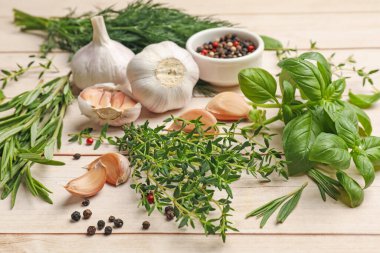 Beyaz ahşap masada farklı taze otlar ve baharatlar, yakın plan.