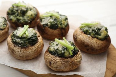 Beyaz ahşap masada servis edilen lezzetli mantarlar, yakın plan.