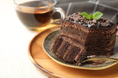 Nane şekerli ve beyaz masadaki çayla birlikte bir parça lezzetli çikolatalı kek, yakın plan. Metin için boşluk