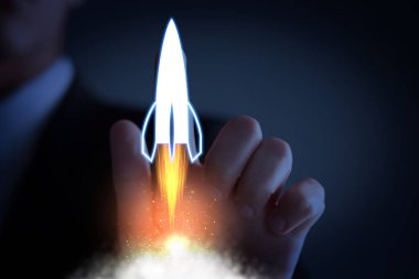 İş, başarılı bir başlangıç. Koyu mavi arkaplana karşı sanal ekranda roket fırlatan adam, yakın plan