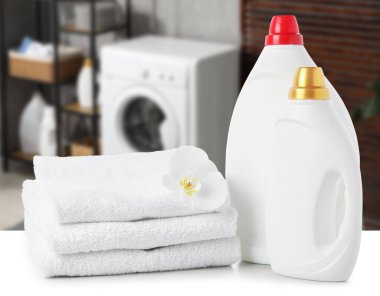 Kumaş yumuşatıcı, deterjan ve havlular çamaşır odasındaki masada.