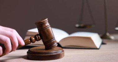 Tahta masadaki tokmaklı yargıç, yakın plan.