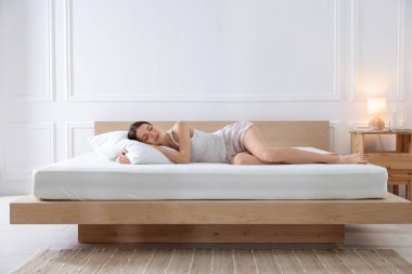 Evde ortopedik yatakta uyuyan bir kadın.