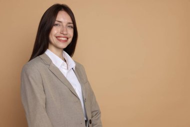Bej arka planda takım elbiseli mutlu kadın, mesaj için boşluk