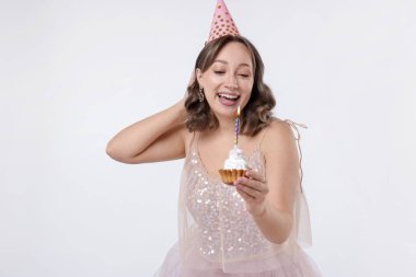 Doğum günü kutlaması. Beyaz arka planda kek yiyen kadın.