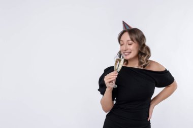 Doğum günü kutlaması. Beyaz arka planda bir bardak köpüklü şarabı olan kadın. Metin için boşluk