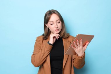 Açık mavi arka planda modern tabletli kadın