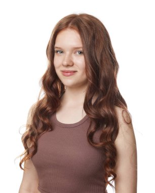 Beyaz arka planda sağlıklı dalgalı saçlı güzel bir genç kızın portresi.