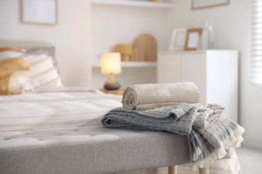 Odasında yumuşak çarşaflar ve battaniyeler olan rahat bir yatak, yakın plan. Ev tekstili