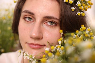 Papatya çiçekli güzel bir kadının portresi, yakın plan.