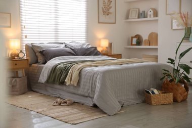 Odasında yumuşak çarşaflar ve battaniyeler olan rahat bir yatak. Ev tekstili