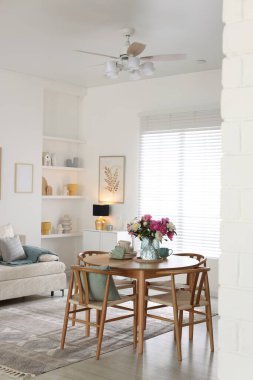 Güzel çiçekli yemek masası ve bulaşık takımı odada, mesaj için yer var. İç tasarım