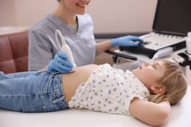 Sonograf, klinikte küçük bir kızın karın ultrasonu muayenesi yapıyor.
