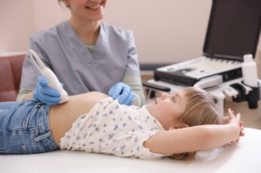 Sonograf, klinikte küçük bir kızın karın ultrasonu muayenesi yapıyor.