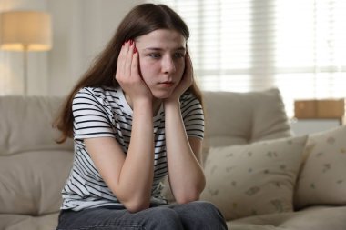 Evdeki kanepede depresif bir genç kız. Metin için boşluk