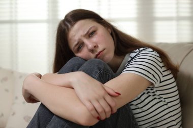 Evdeki kanepede depresif genç kız.