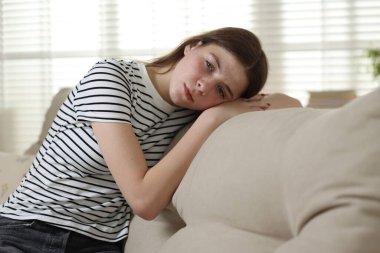 Evdeki kanepede depresif genç kız.