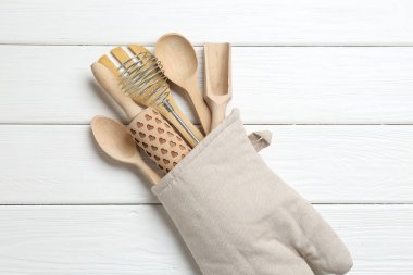 Farklı mutfak aletleri fırın eldiveni beyaz ahşap masa, üst görünüm