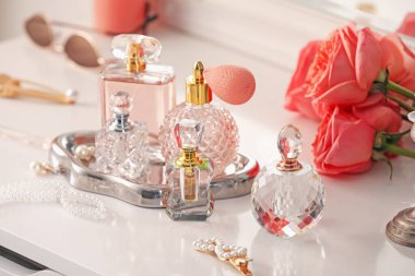 Farklı parfümlerden, aksesuarlardan ve çiçeklerden oluşan şişeler.