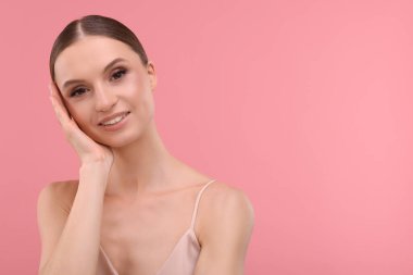 Pembe arka planda güzel bir genç kadının portresi, metin için boşluk