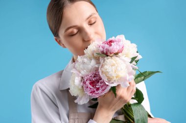 Açık mavi arka planda güzel şakayık demeti olan bir çiçekçi.