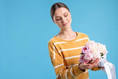 Açık mavi arka planda şakayık demeti olan güzel bir kadın, mesaj için yer var.