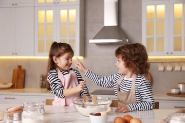 Yemek tarifi. Sevimli çocuklar mutfaktaki masada kurabiye için para kazanıyor.