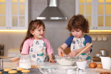 Yemek tarifi. Sevimli çocuklar mutfaktaki masada kurabiye için para kazanıyor.