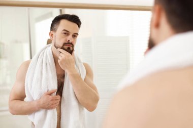 Banyoda aynaya bakmadan önce yakışıklı bir adam.