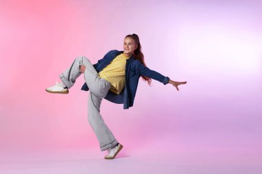 Renkli arka planda dans eden şık elbiseli bir kız.