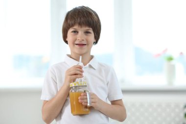Evde elinde bir kavanoz portakal suyu olan şirin bir çocuk. Tazeleyici içecek.
