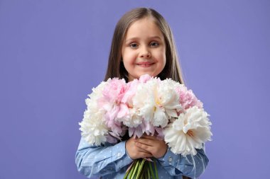 Mor arka planda bir buket güzel şakayığı olan tatlı küçük bir kız.